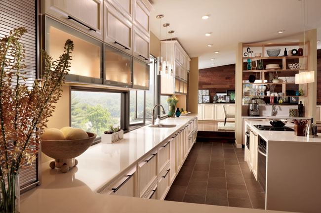 Kendrick Maple Square in Parchment shines in this contemporary kitchen. Glass doors and open shelves play up the natural setting while long banks of cabinetry lead the eye across the space for a streamlined effect.